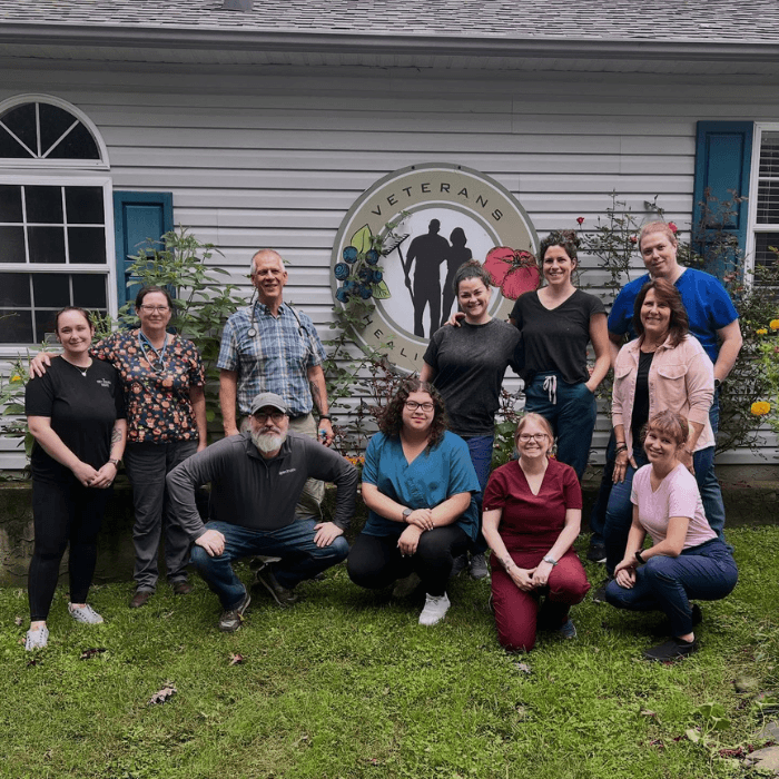 team member smiling with dog